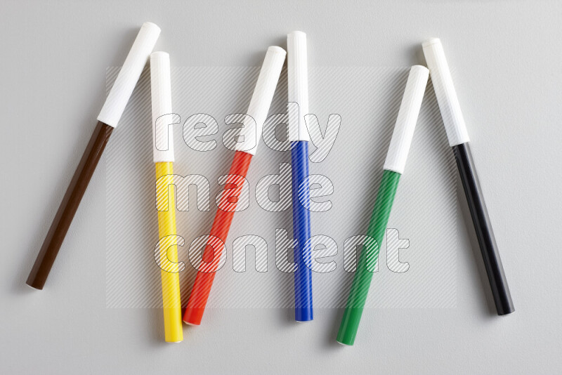 An arrangement of coloring pens in different colors on grey background