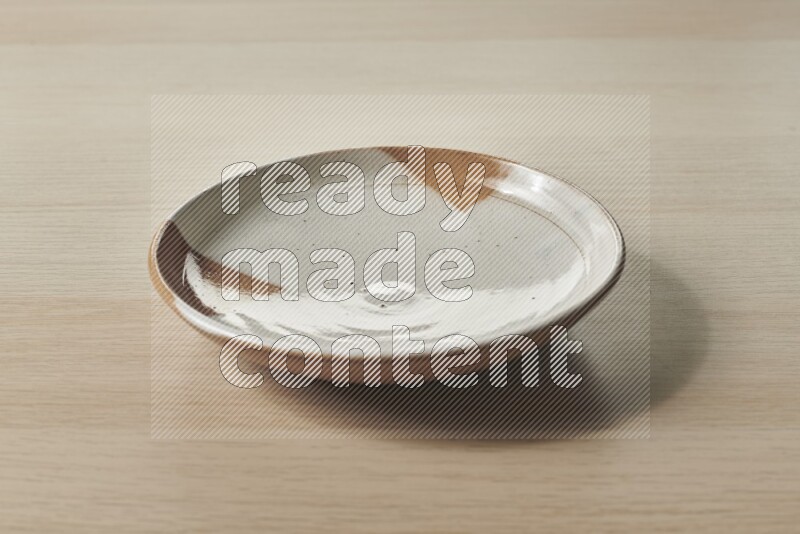 A multicolored pottery plate on light wooden background
