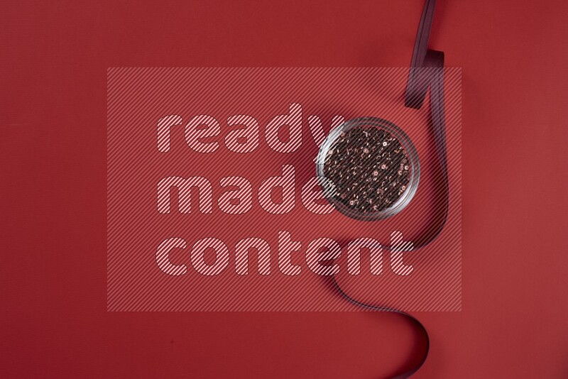 مجموعة من أدوات الخياطة والتفصيل حمراء اللون على خلفية حمراء