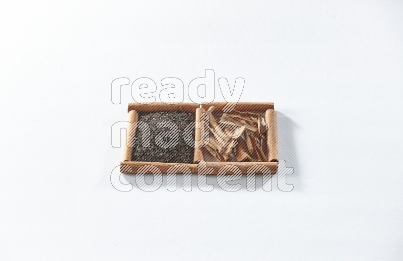 2 squares of cinnamon sticks full of black tea and cinnamon on white flooring