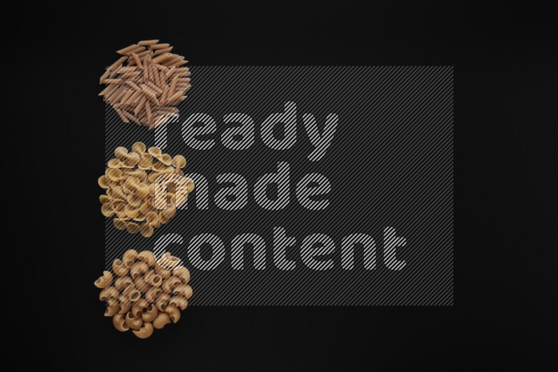 Different pasta types in 3 bunches on black background