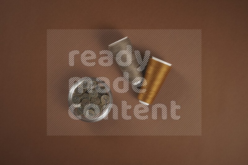 A brown collection of sewing and tailoring tools arranged on a brown background