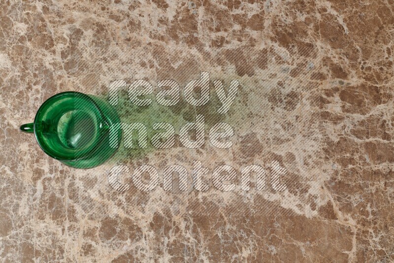 A colored glass jug on beige marble background