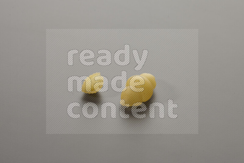 Shells pasta with other types of pasta on grey background