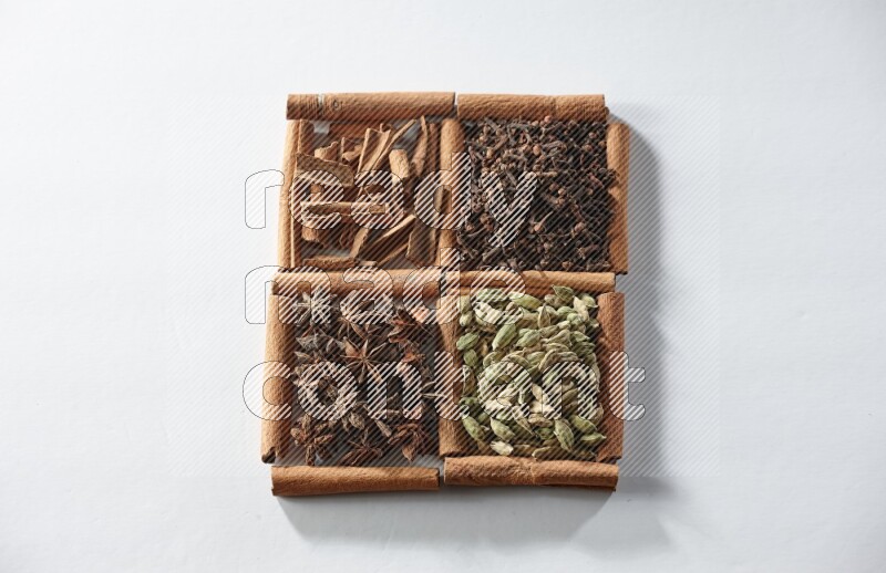 4 squares of cinnamon sticks full of cardamom, star anise, cloves and cinnamon on white flooring