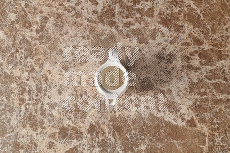 A ceramic milk jug on beige marble background
