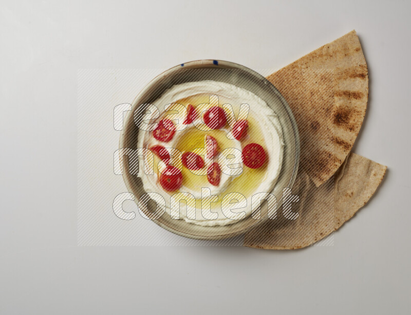 Lebnah garnished with cherry tomato in a grey pottery plate on a white background