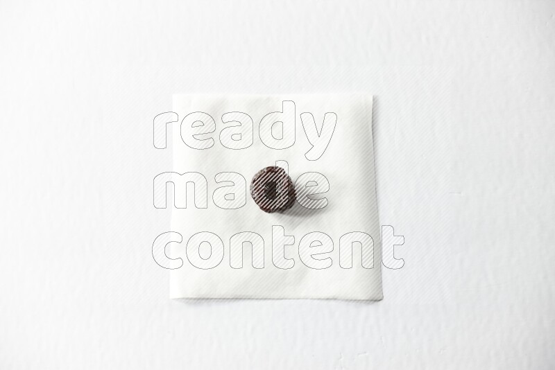 A dried plum on a piece of paper on a white background in different angles
