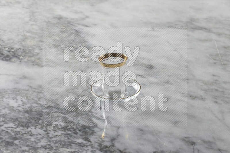 Glassware such as a coffee pot, a cup and a saucer on grey marble background