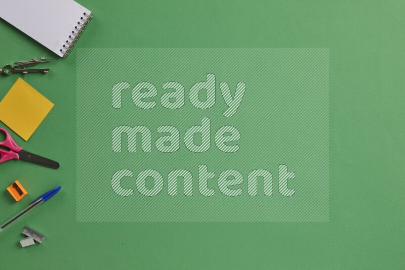 Different school supplies on green background