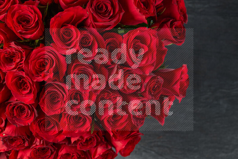 A luxurious bouquet of red roses on black marble background