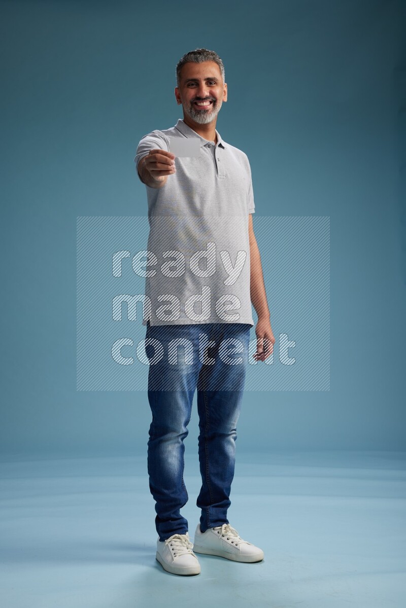 Man Standing holding ATM on blue background
