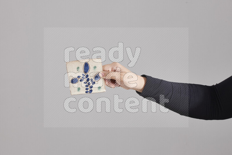 A woman in black abaya holding different pottery essentials in different positions