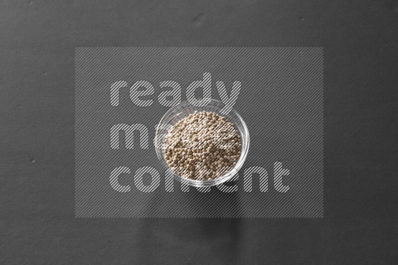 فلفل أبيض في وعاء زجاجي علي خلفية سوداء