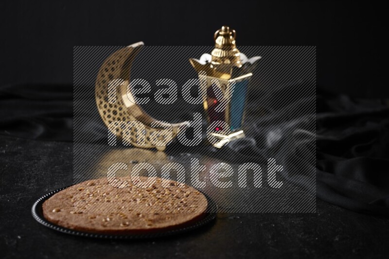 بسبوسة مع فوانيس علي خلفية سوداء خشبية