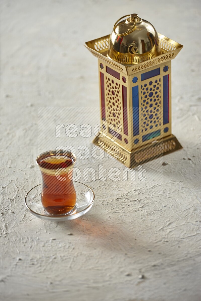 A golden lantern with different drinks, dates, nuts, prayer beads and quran on textured white background