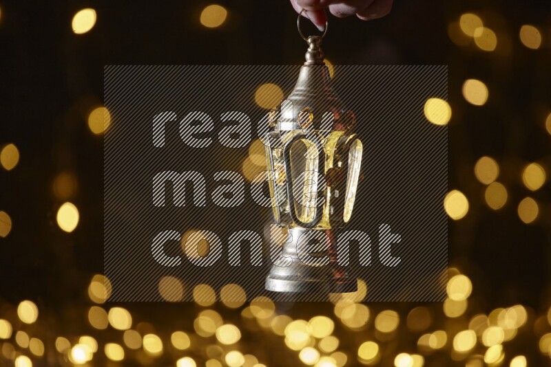 A traditional ramadan lantern surrounded by glowing fairy lights in a dark setup