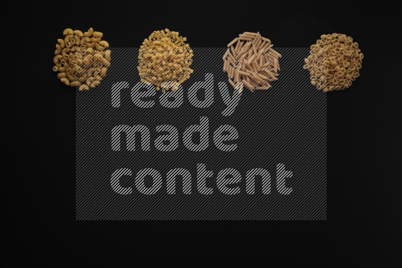 Different pasta types in 4 bunches on black background