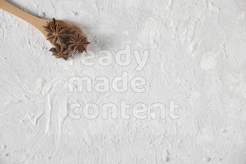 Star Anise in a wooden spoon on white flooring