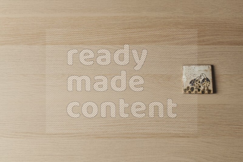 A decorative pottery coaster on light wooden background