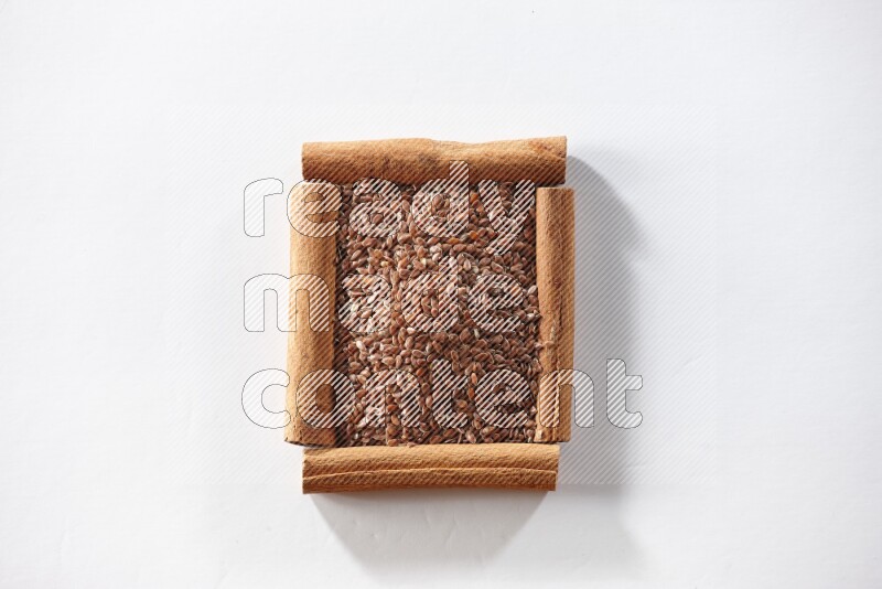 A single square of cinnamon sticks full of flaxseeds on white flooring