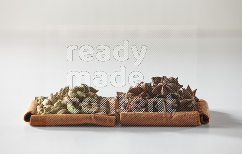 2 squares of cinnamon sticks full of star anise and cardamom on white flooring