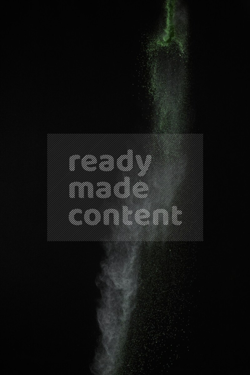 A side view of green powder explosion on black background