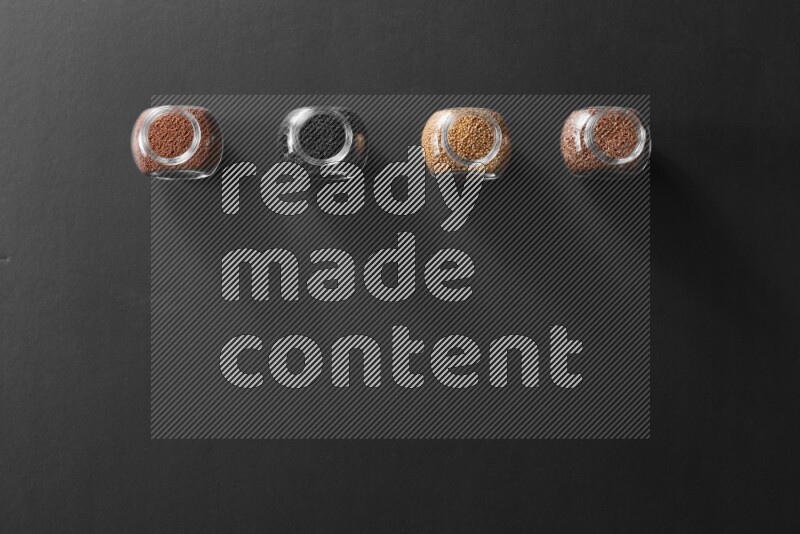 حبة البركة و حبوب الخردل وحبوب الكتان وحب الرشاد في أوعية زجاجية علي خلفية سوداء