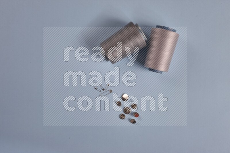 مجموعة من أدوات الخياطة والتفصيل رمادية اللون على خلفية زرقاء