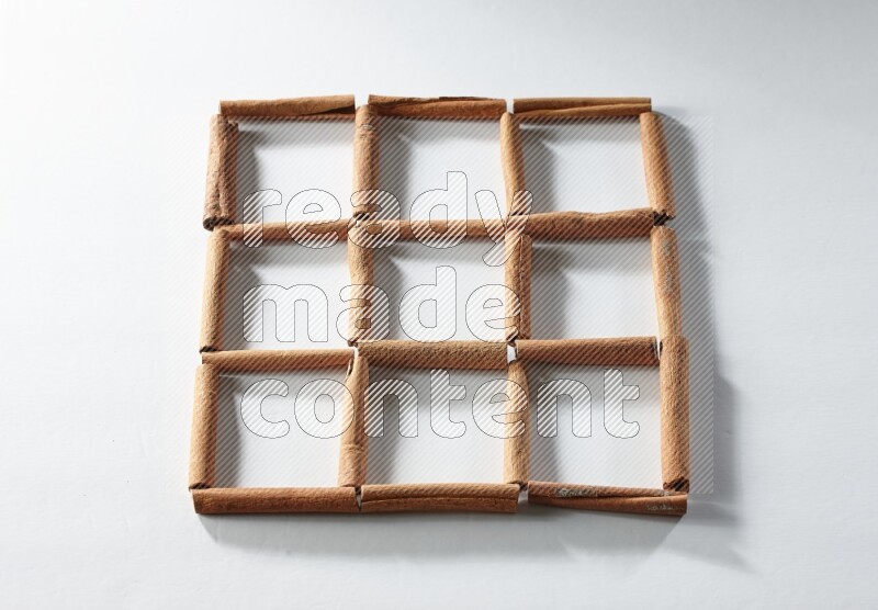 9 empty squares of cinnamon sticks on white flooring