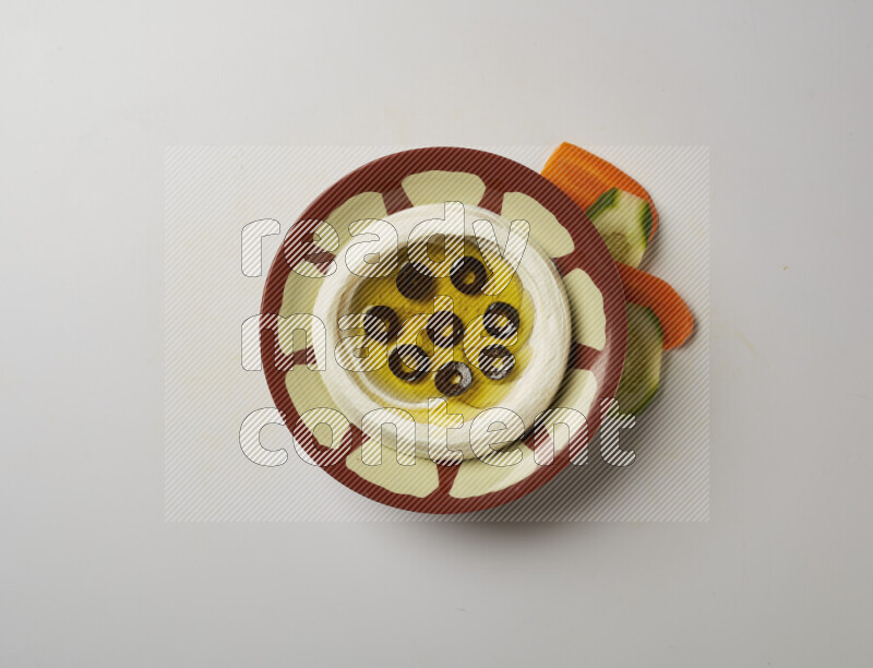 Lebnah garnished with sliced olives in a traditional plate on a white background