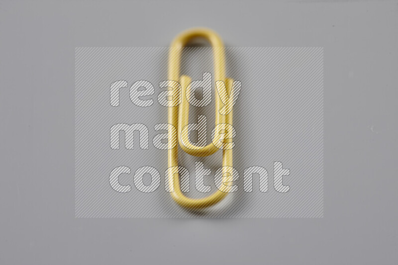 Yellow paper clips isolated on a grey background