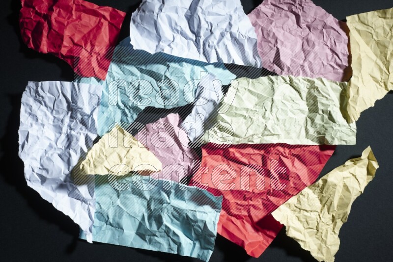 Crumpled multicolored paper on black background