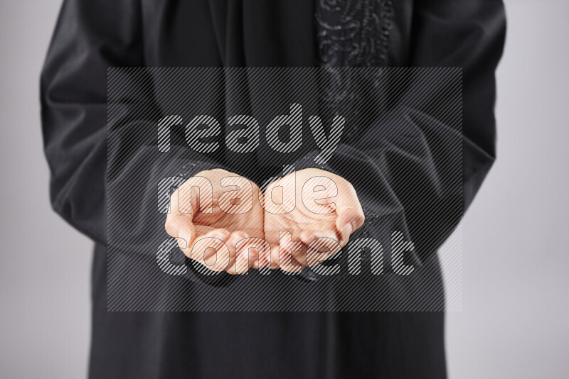 Woman in abaya holding different kinds of spices in different positions
