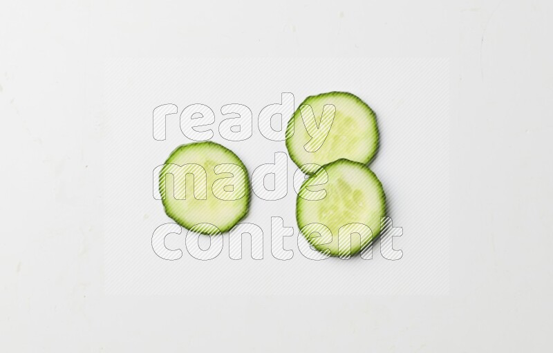 three cucumber slices on white background