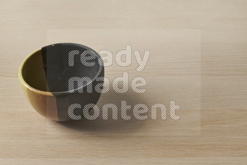 A multicolored pottery bowl on light wooden background