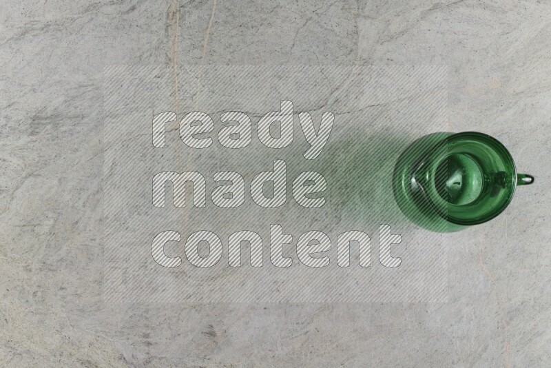 A colored glass jug on grey marble background