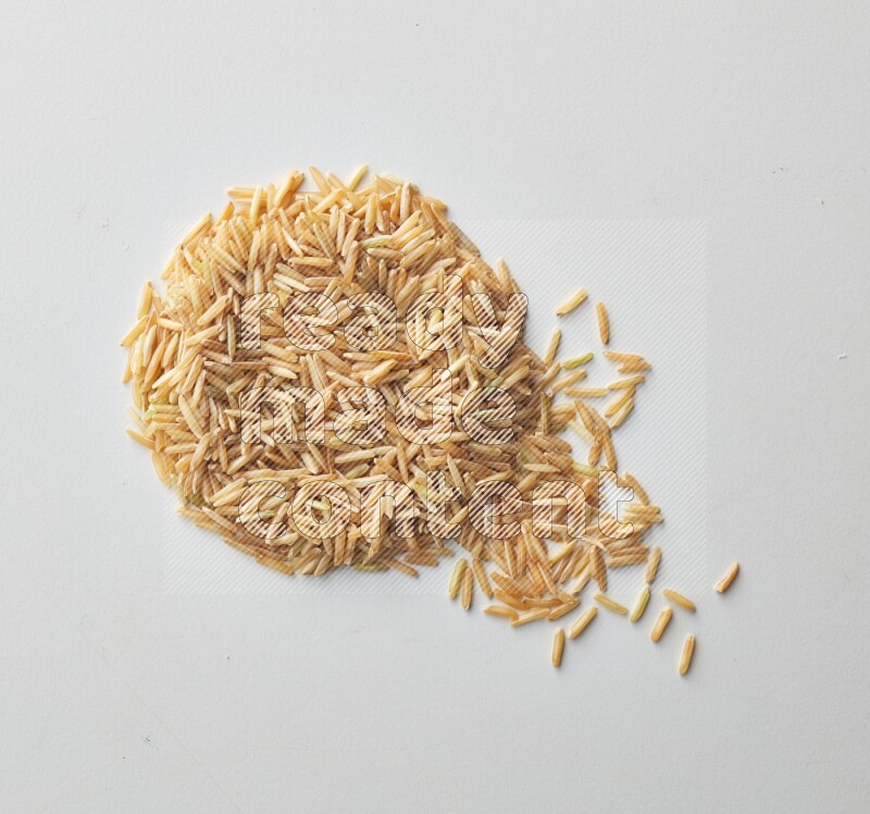 Top-view shot of long grain brown rice on white background