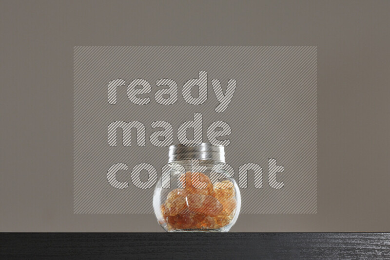 Gum arabic in a glass jar on black background