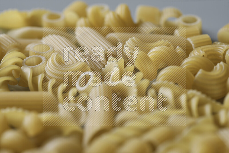 Different pasta types on light blue background
