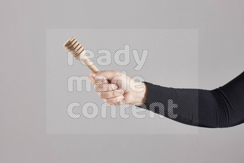 امرأة ترتدي عباءة سوداء تحمل أدوات خشبية مختلفة في أوضاع متعددة