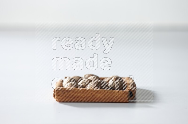 A single square of cinnamon sticks full of nutmeg on white flooring
