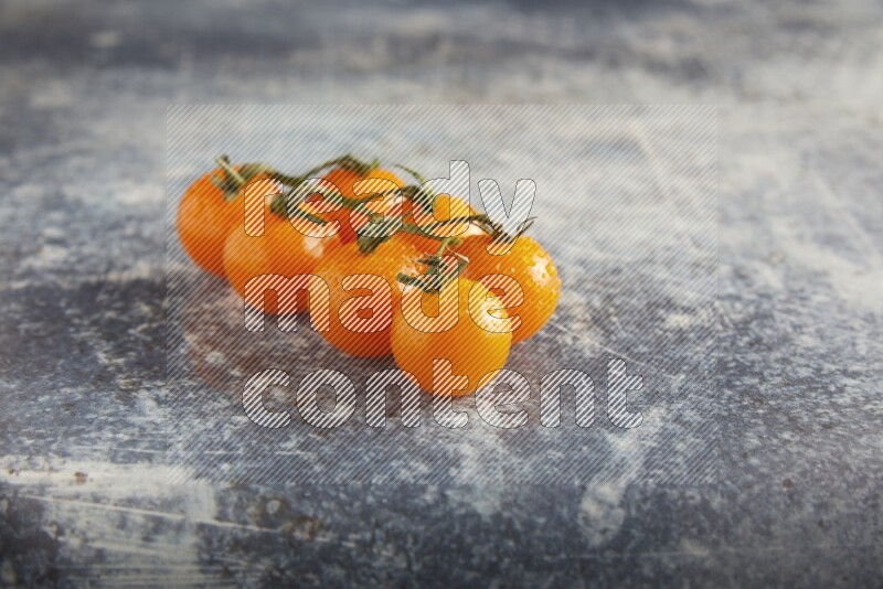 Orange cherry tomato vein on a textured rusty blue background 45 degree