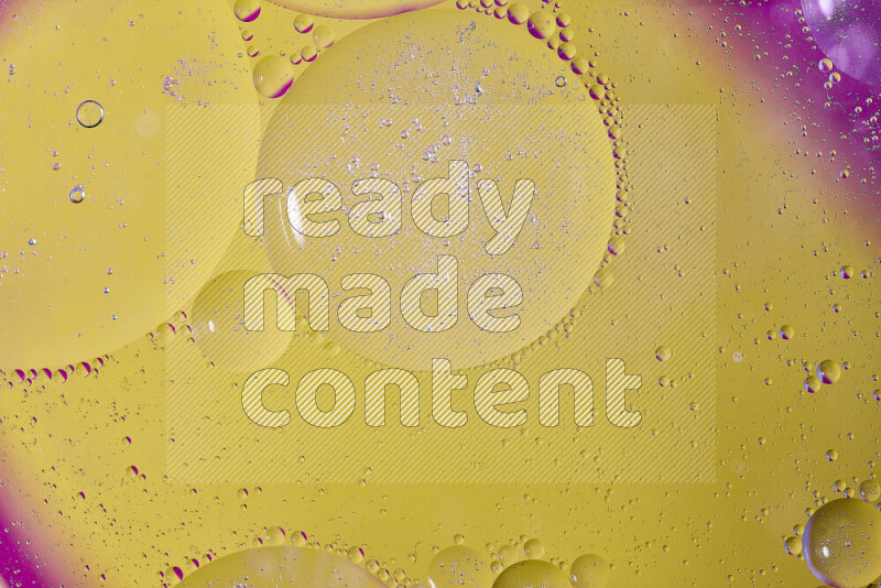 Close-ups of abstract oil bubbles on water surface in shades of yellow and pink