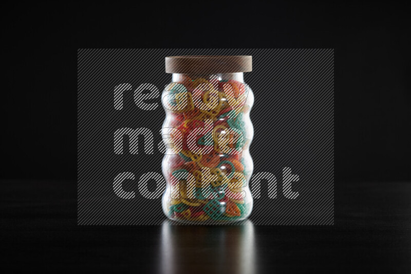Snacks in a glass jar on black background