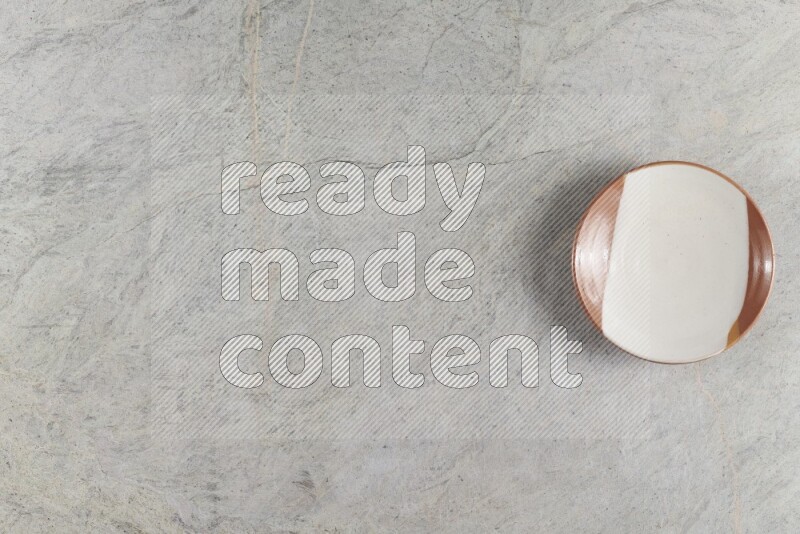 A multicolored pottery plate on grey marble background