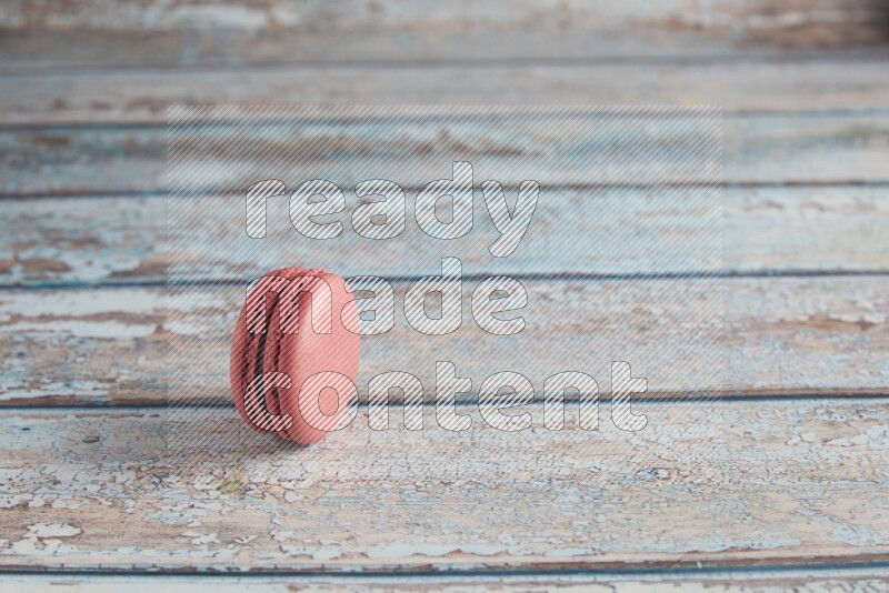 45º Shot of Pink Raspberry macaron on light blue wooden background