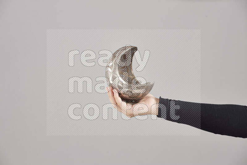 A woman in black abaya holding different ramadan lanterns in different positions