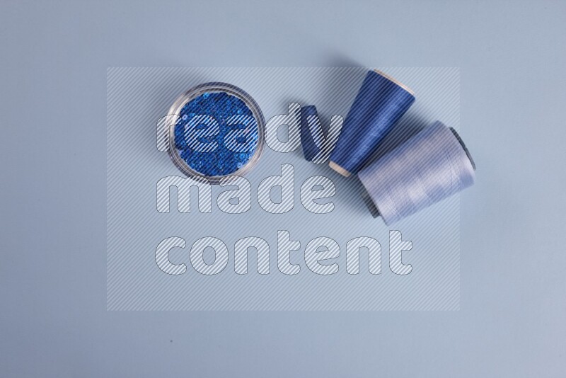 مجموعة من أدوات الخياطة والتفصيل زرقاء اللون على خلفية زرقاء