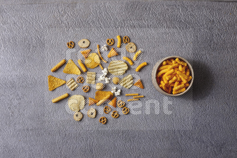 Assorted snacks in pottery bowls on grey background